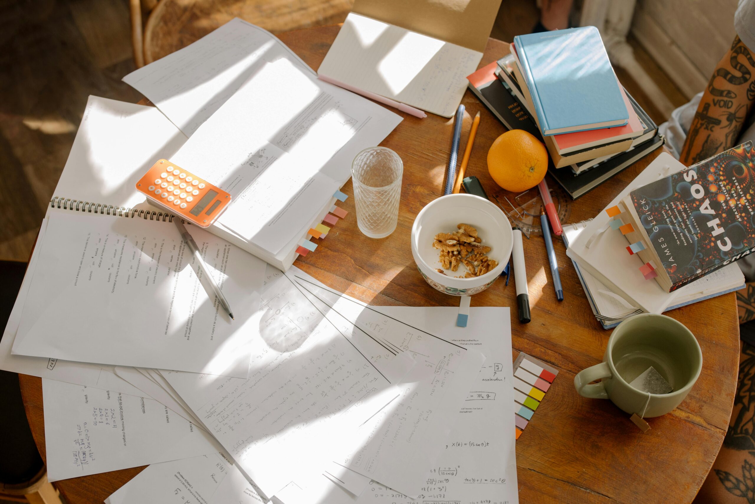 A table with different documents and books which could use some organization.