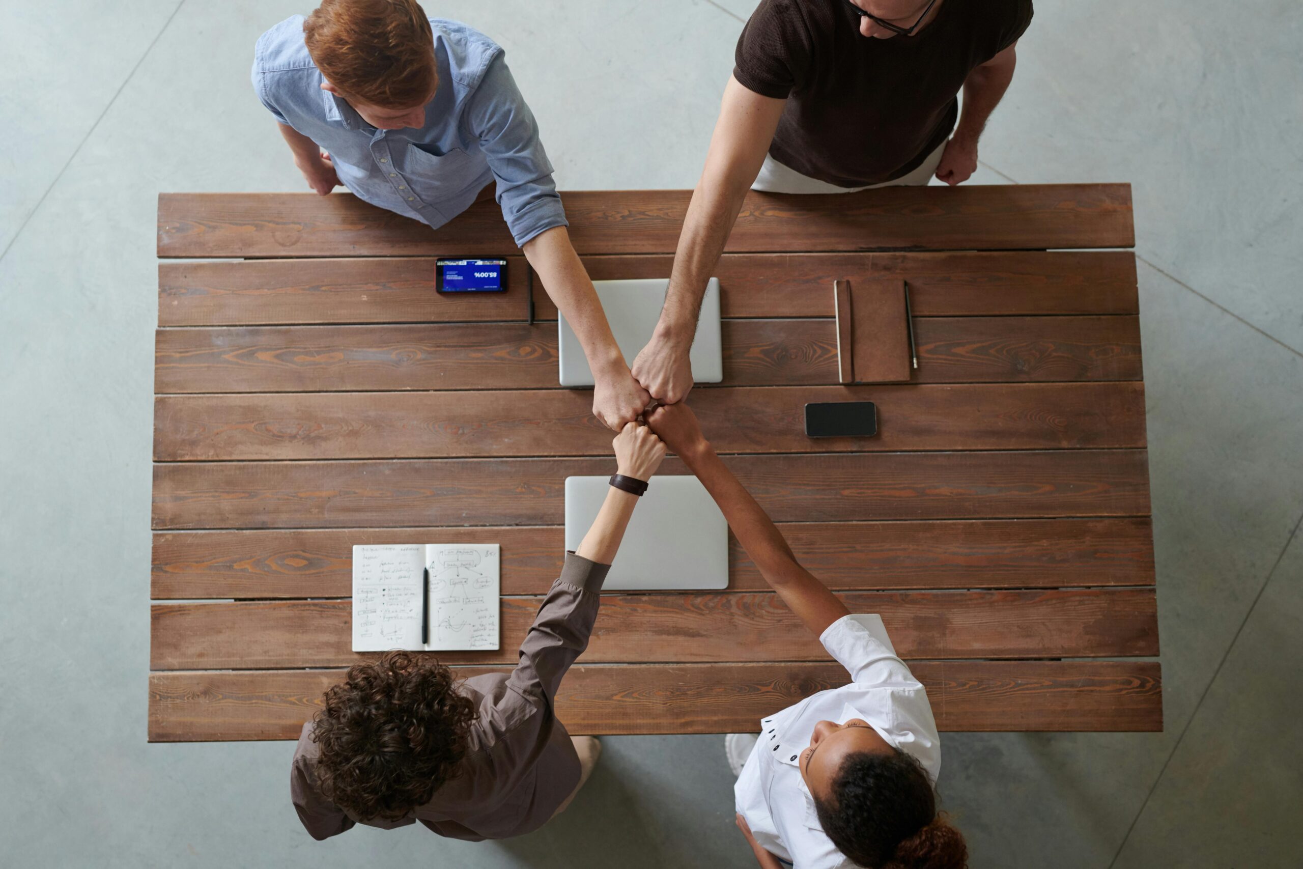 Top view of meeting participants doing a fist bump.